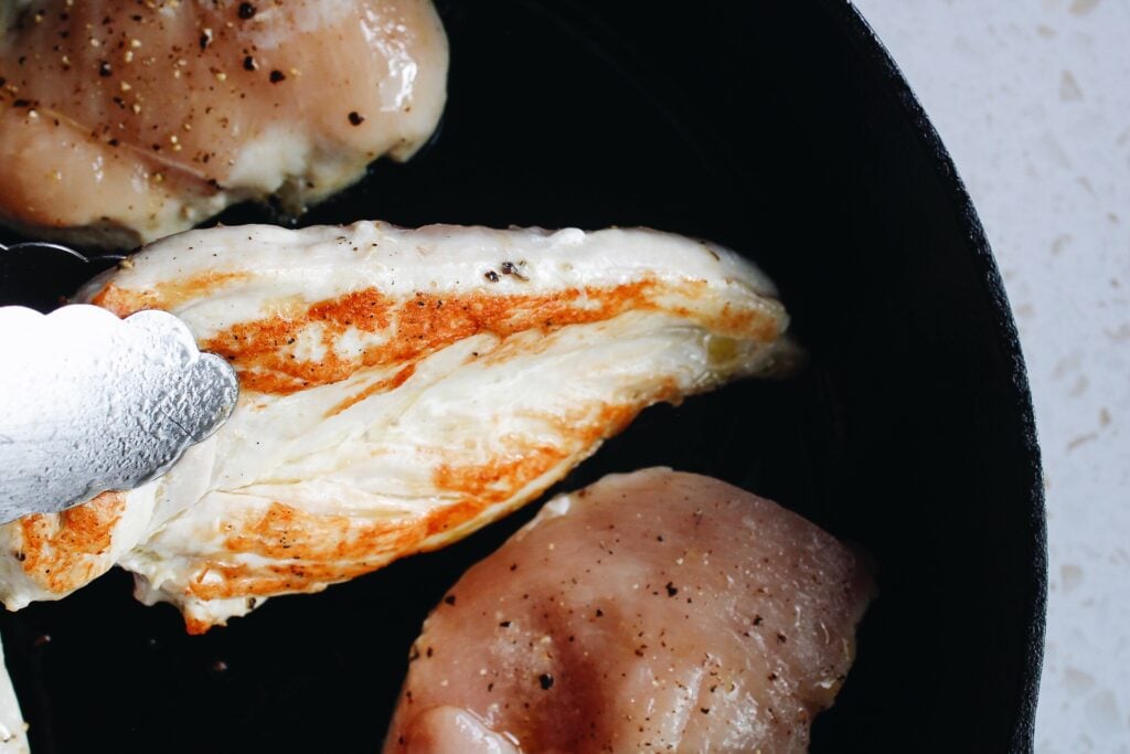 chicken breast being flipped