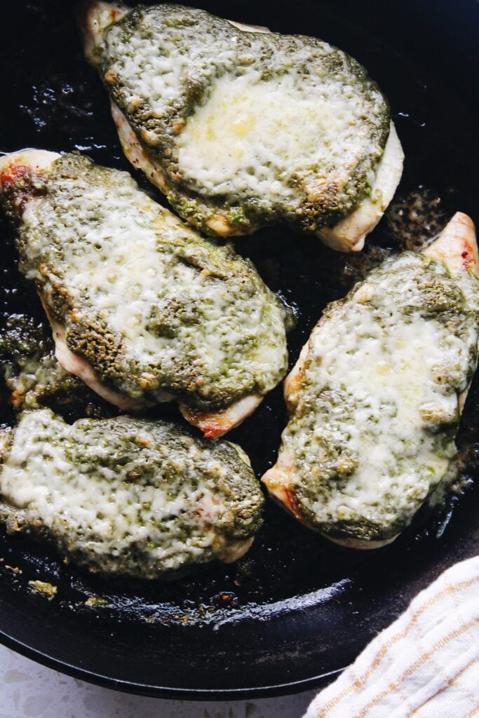 pesto baked chicken in a cast iron skillet 
