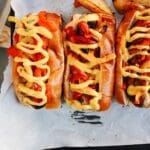 grilled brats on a tray lined with parchment papper