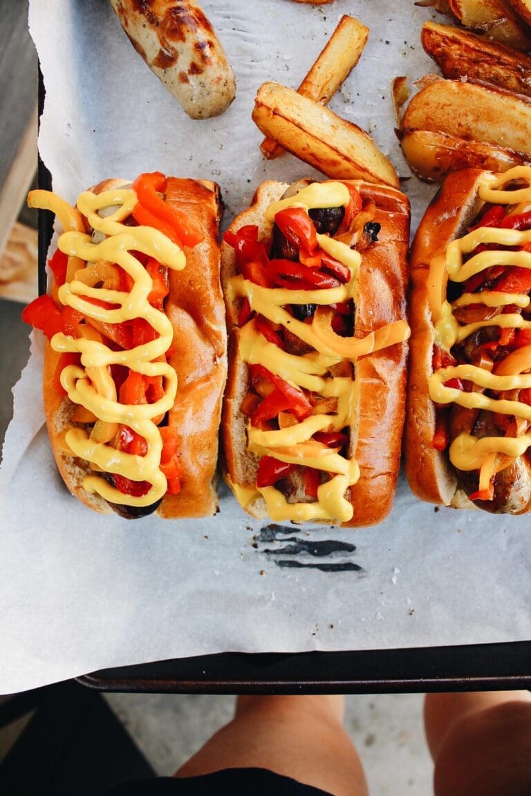 grilled brats on a tray lined with parchment papper