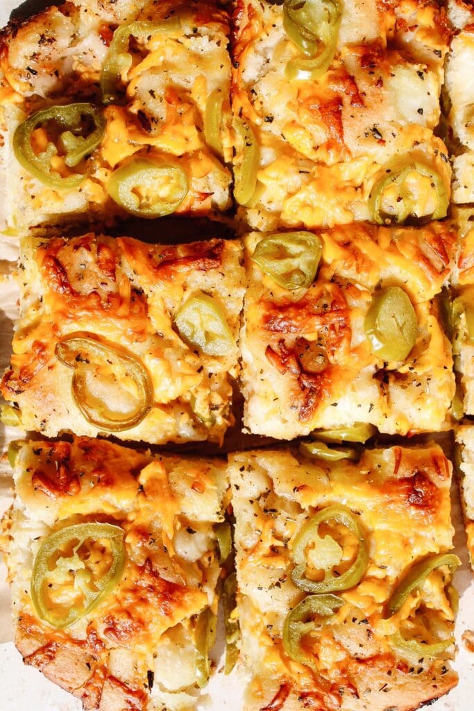 jalapeno cheddar focaccia bread cut into squares for serving.